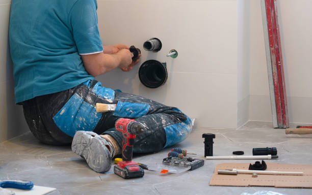 Plumber fitting a pipe in the bathroom.
